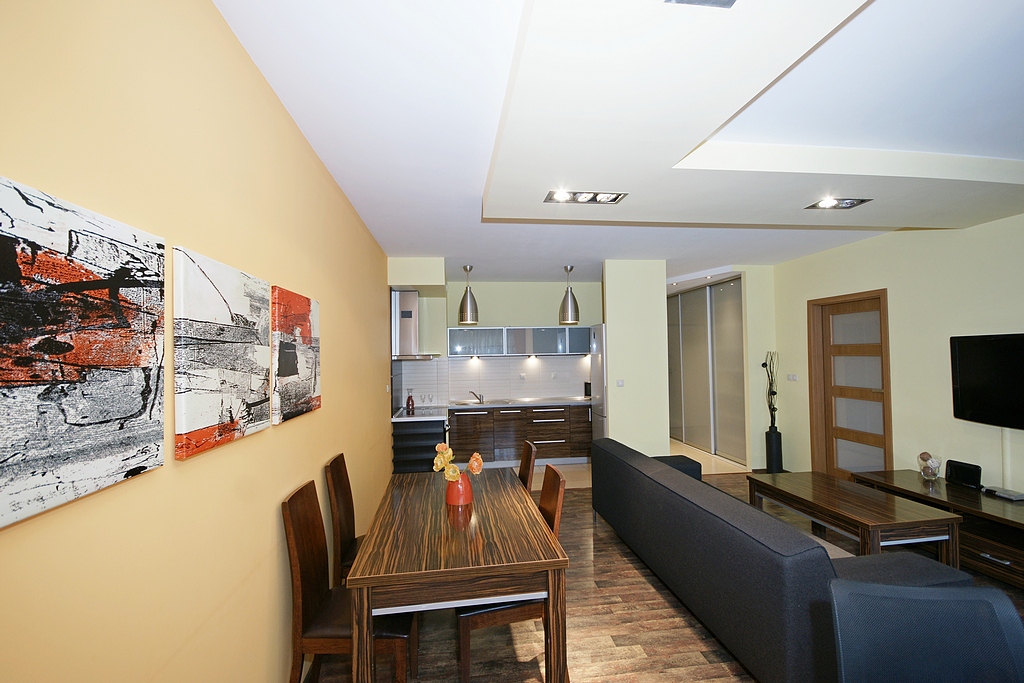 widok z innej perspektywy na jadalnię oraz salon w luksusowym apartamencie do wynajmu w Katowicach