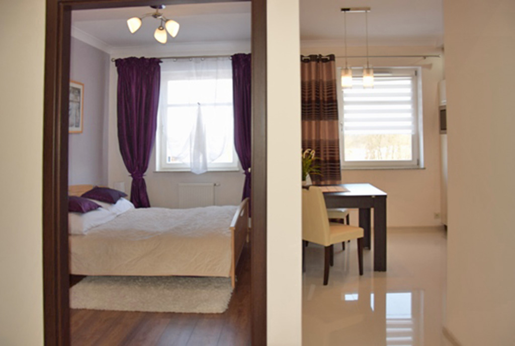 po lewej sypialnia, po prawej kuchnia w luksusowym apartamencie w Słupsku na wymajem