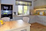na zdjęciu jadalnia i kuchnia w luksusowym apartamencie na Mazurach na sprzedaż
