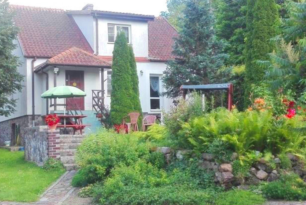 widok od strony ogrodu na ekskluzywną willę na Mazurach na sprzedaż