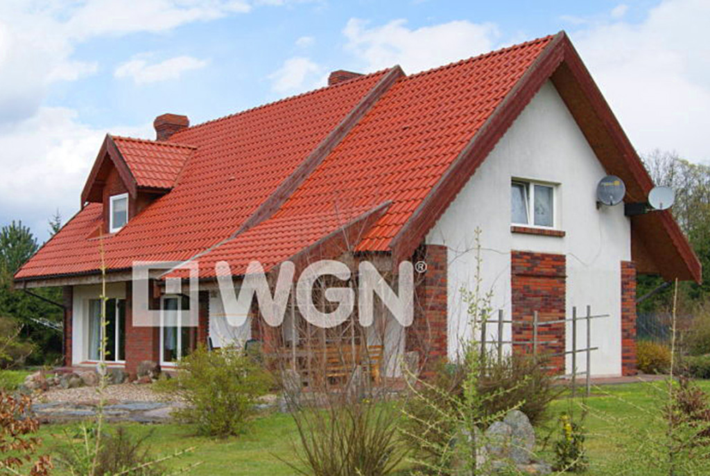 widok z boku na fragment działki oraz luksusową willę na Mazurach na sprzedaży