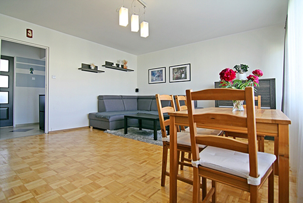 na pierwszym planie jadalnia, w oddali salon w luksusowym apartamencie w Wieluniu na sprzedaż