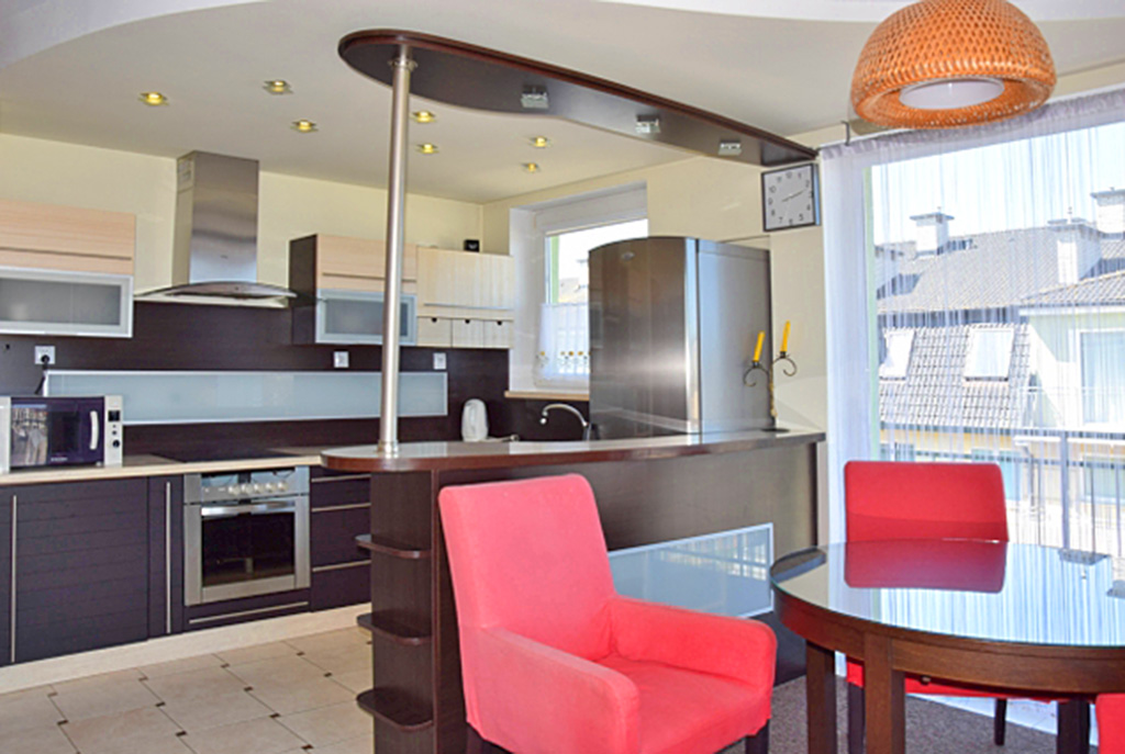 widok na jadalnię i aneks kuchenny w luksusowym apartamencie do wynajmu nad morzem