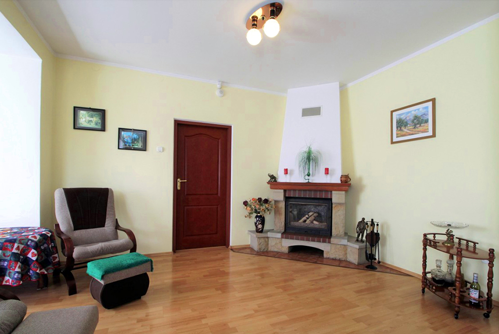widok na salon z kominkiem w luksusowej willi do sprzedaży w okolicach Krakowa