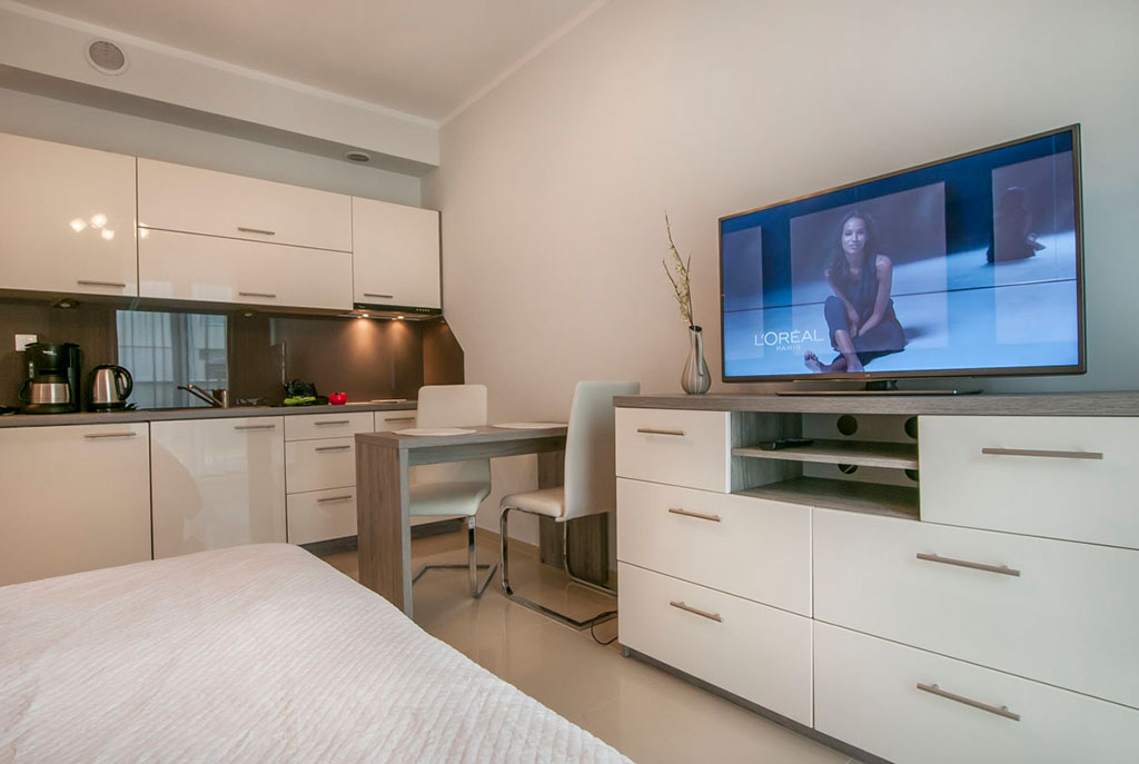 widok od strony salonu na umeblowany nowocześnie aneks kuchenny w luksusowym apartamencie do sprzedaży nad morzem