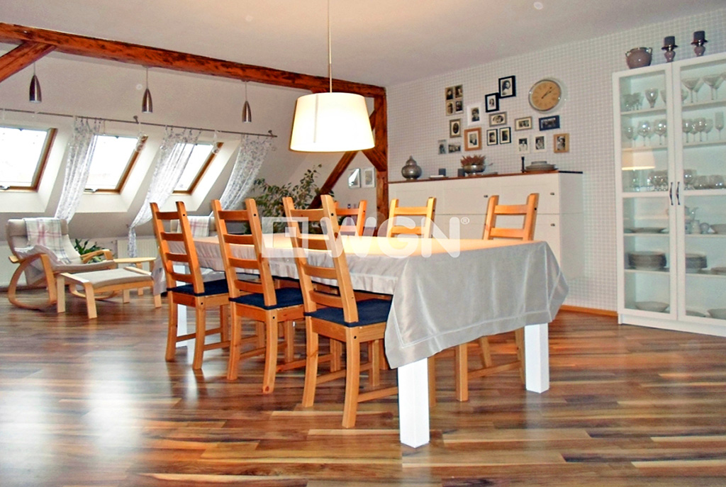 na pierwszym planie jadalnia, w oddali kuchnia w ekskluzywnym apartamencie do sprzedaży w Legnicy