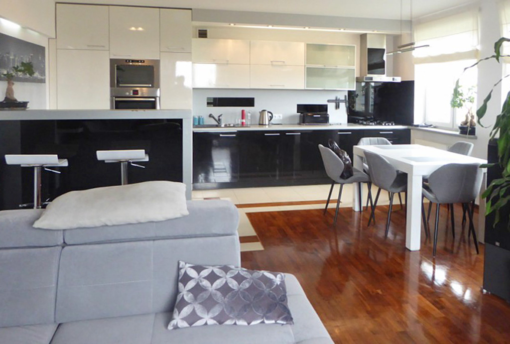 widok od strony salonu na nowoczesny aneks kuchenny w ekskluzywnym apartamencie do sprzedaży w Piotrkowie Trybunalskim