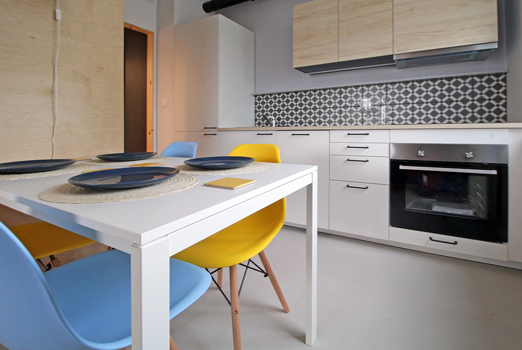 widok od strony jadalni na aneks kuchenny w luksusowym apartamencie na wynajem w Krakowie