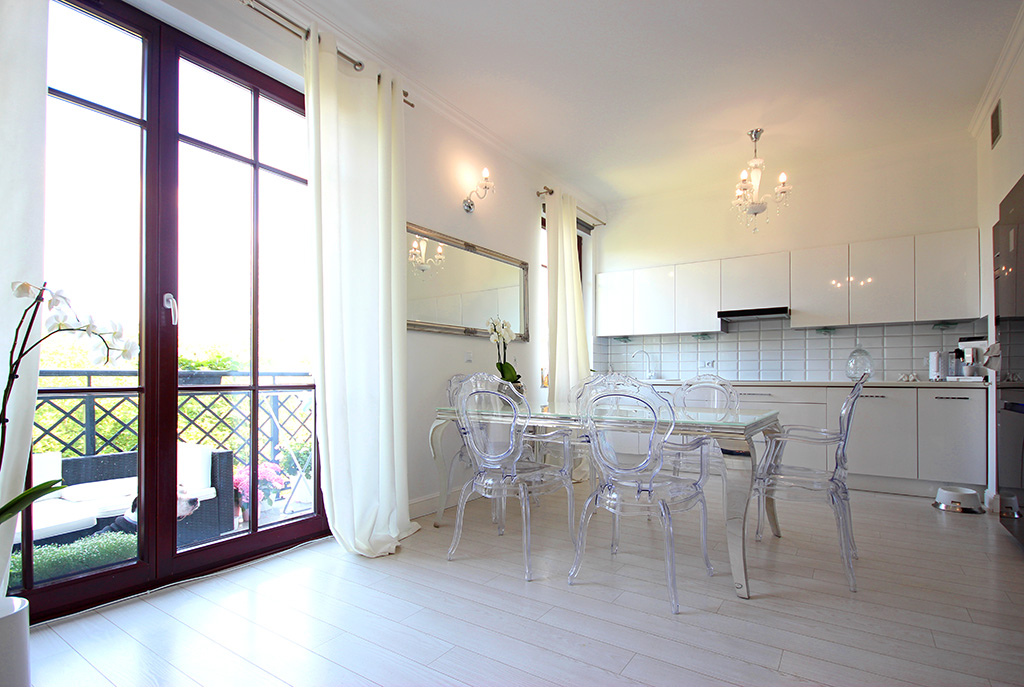 widok na umeblowaną jadalnię i aneks kuchenny w luksusowym apartamencie w Szczecinie na sprzedaż