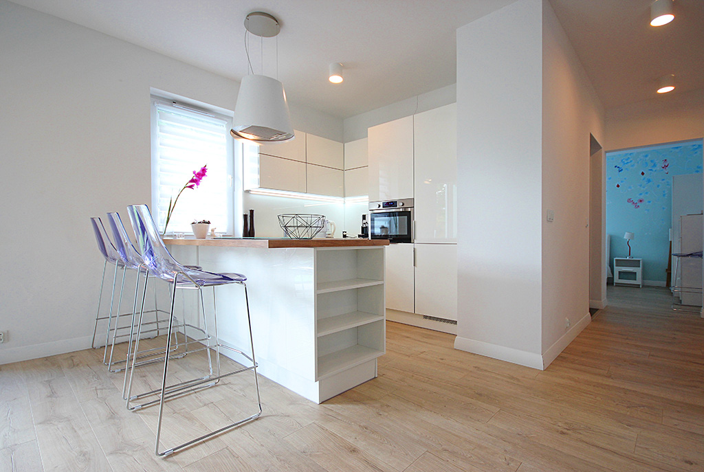 na pierwszym planie jadalnia,w oddali kuchnia w luksusowym apartamencie do wynajmu w Szczecinie