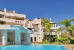 widok od strony basenu na apartamentowiec w Costa del Sol, Marbella (Hiszpania), w którym znajduje się oferowany na sprzedaż luksusowy apartament