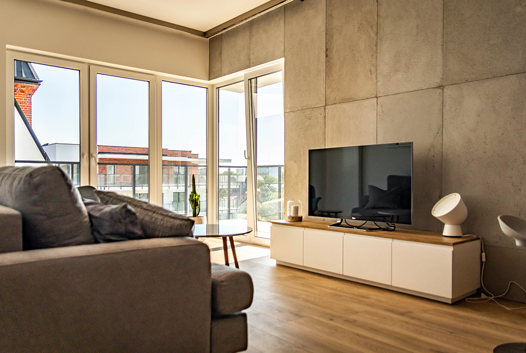 widok na salon oraz taras przy luksusowym apartamencie do wynajmu w Wieluniu