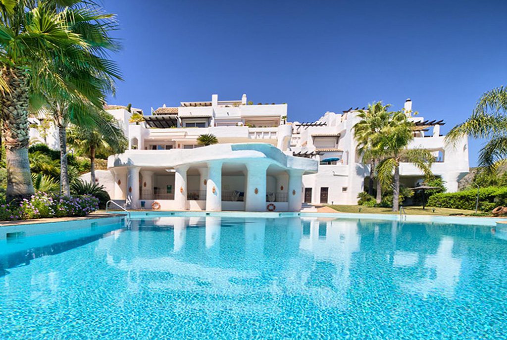 widok od strony basenu na ekskluzywny budynek, w którym znajduje się oferowany do sprzedaży luksusowy apartament Hiszpania (Costa del Sol, Marbella)