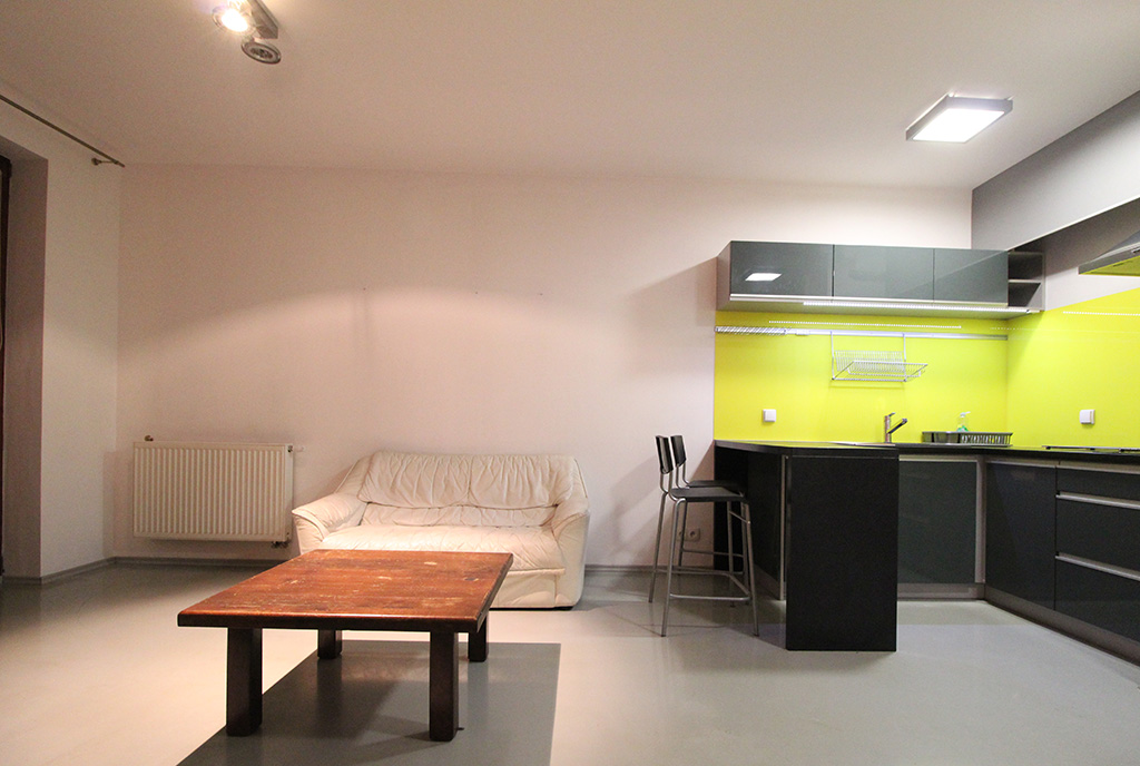 widok na umeblowaną w nowoczesnym stylu kuchnię w ekskluzywnym apartamencie do wynajmu Kraków