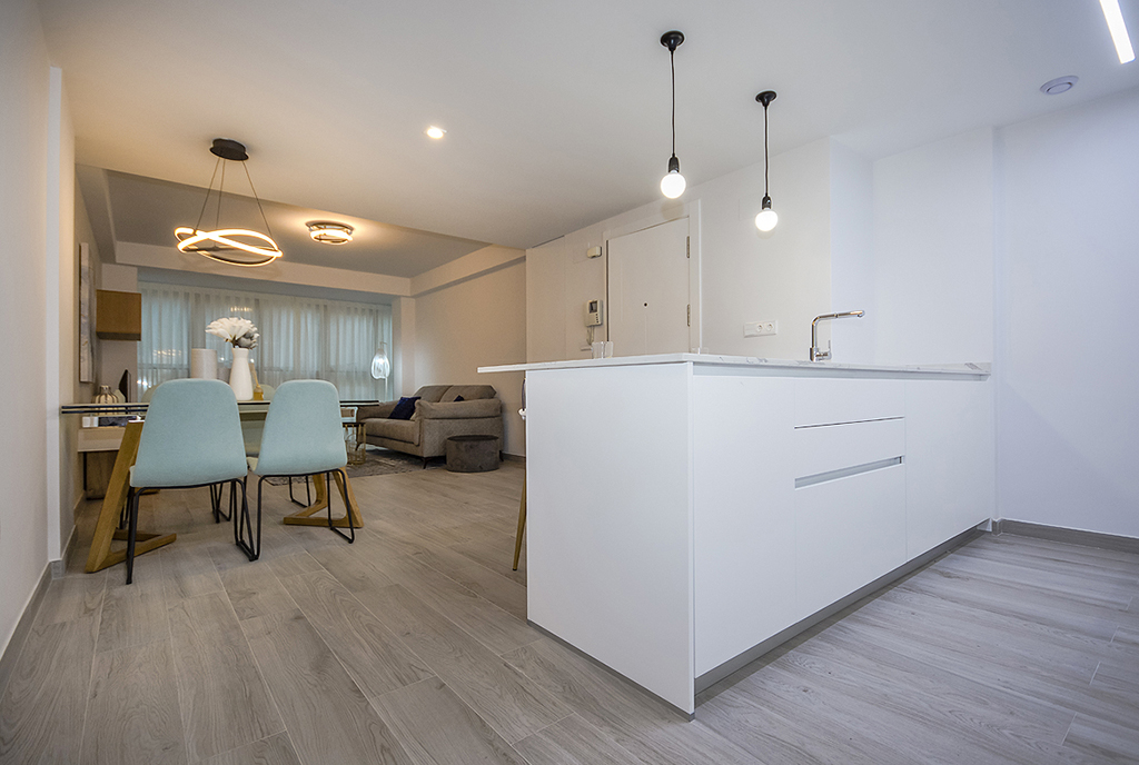 na pierwszym planie kuchnia, w oddali salon w luksusowym apartamencie na sprzedaż Hiszpania (Orihuel)