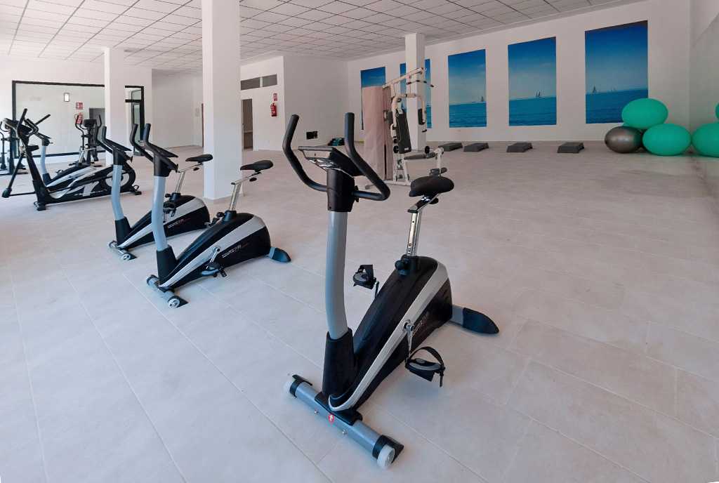 wyposażona siłownia w częściach wspólnych apartamentowca, w którym znajduje się oferowany na sprzedaż ekskluzywny apartament Hiszpania (La Zeni)