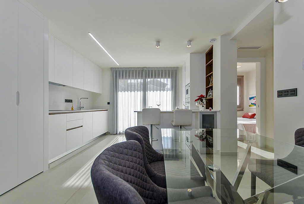 na pierwszym planie jadalnia, w oddali salon ekskluzywnego apartamentu do sprzedaży Hiszpania (Torreviej)