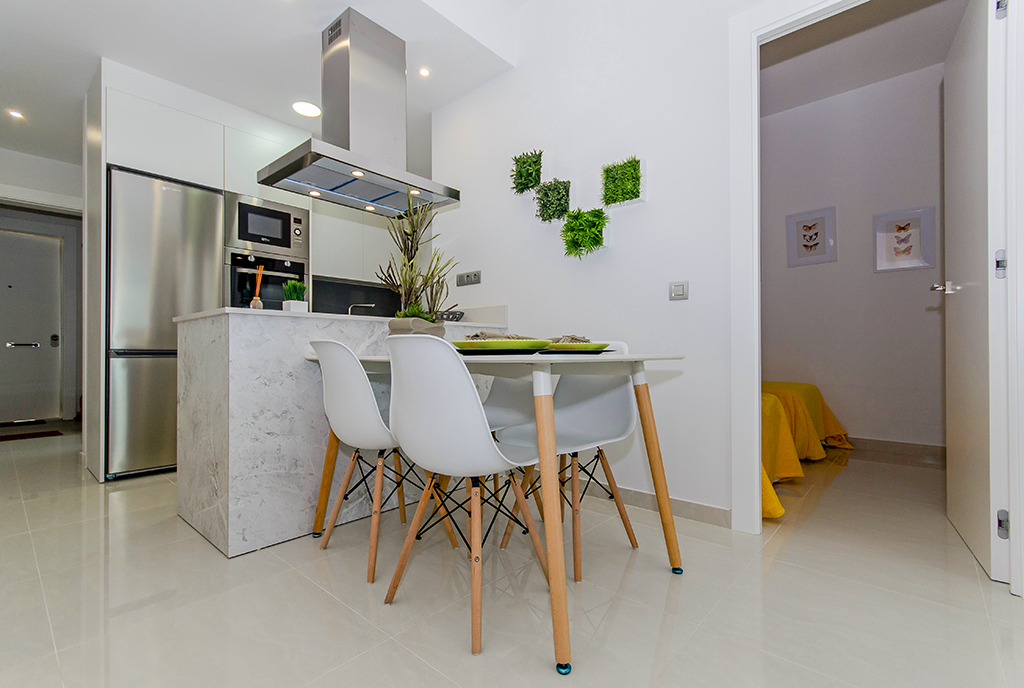 minimalistyczny wystrój jadalni i aneksu kuchennego w ekskluzywnym apartamencie do sprzedaży Hiszpania (Torreviej)