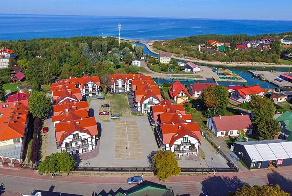 rzut z lotu ptaka pokazujący okolicę, gdzie mieści się oferowany do sprzedaży ekskluzywny apartament nad morzem