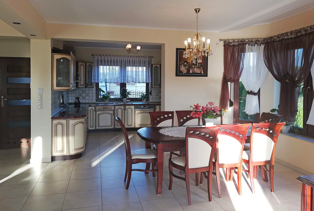 na pierwszym planie jadalnia oraz aneks kuchenny w ekskluzywnej willi do wynajęcia Szczecin