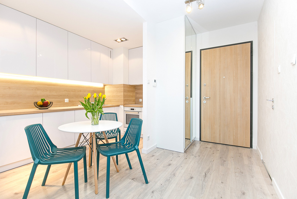 na pierwszym planie jadalnia, w oddali aneks kuchenny w ekskluzywnym apartamencie na wynajem Gdańsk
