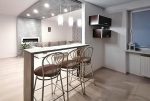 na pierwszym planie jadalnia, w oddali aneks kuchenny w luksusowym apartamencie na sprzedaż Kalisz
