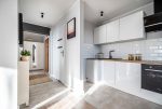 po prawej kuchnia, po lewej hol w luksusowym apartamencie na sprzedaż Kalisz (okolice)