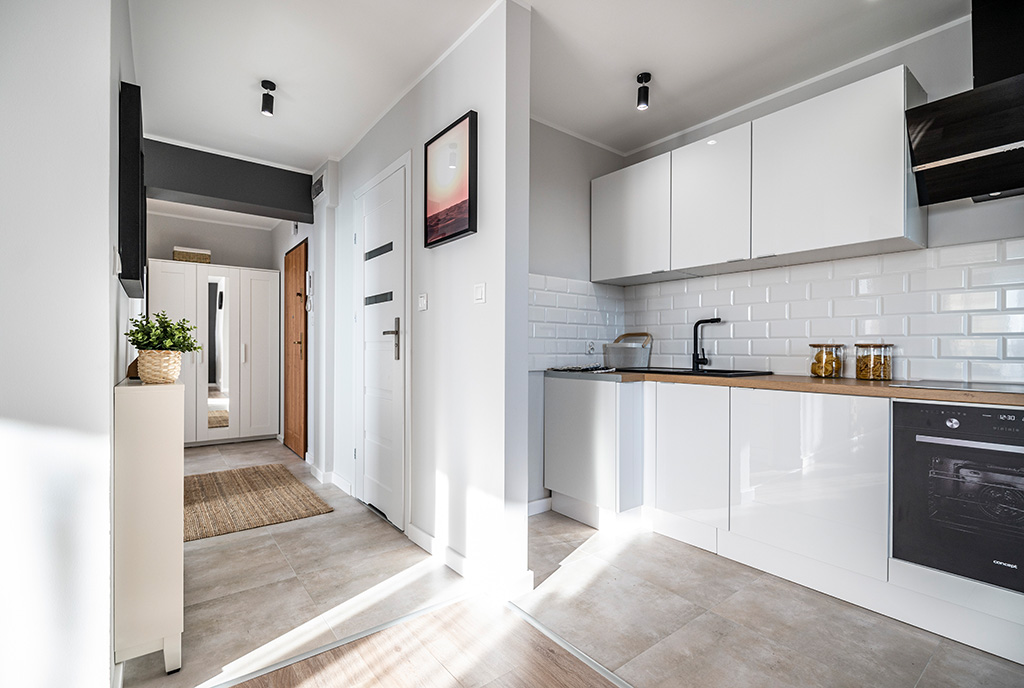 po prawej kuchnia, po lewej hol w luksusowym apartamencie na sprzedaż Kalisz (okolice)
