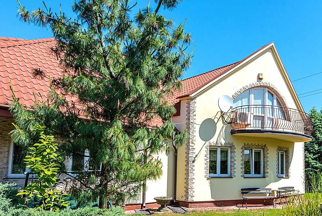 na pierwszym planie zagospodarowany ogród wokół luksusowej willi na sprzedaż Warszawa (okolice)