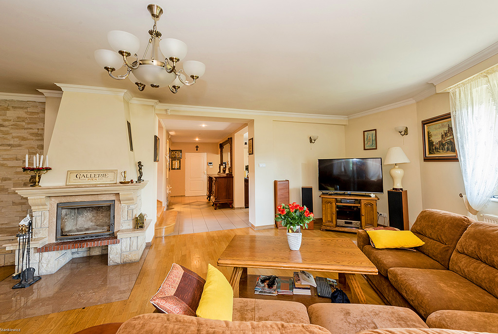 zbliżenie na salon z kominkiem w ekskluzywnej willi na sprzedaż Warszawa (okolice)