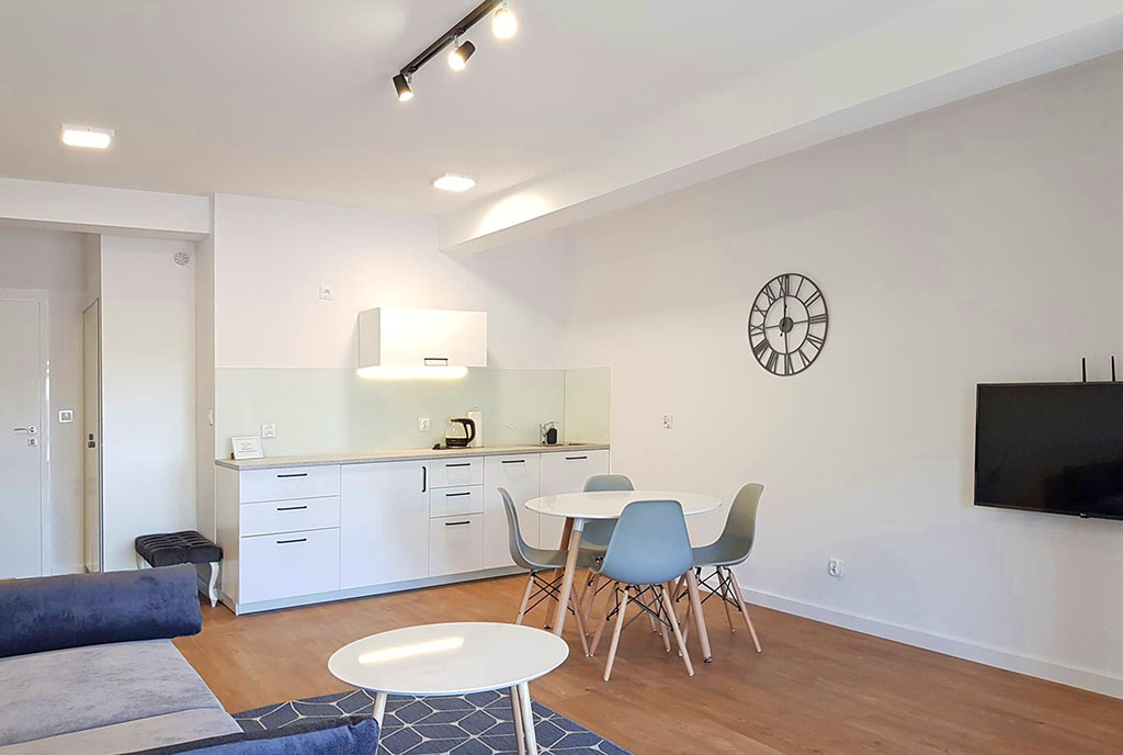 widok na jadalnię oraz aneks kuchenny w luksusowym apartamencie na sprzedaż Mazury