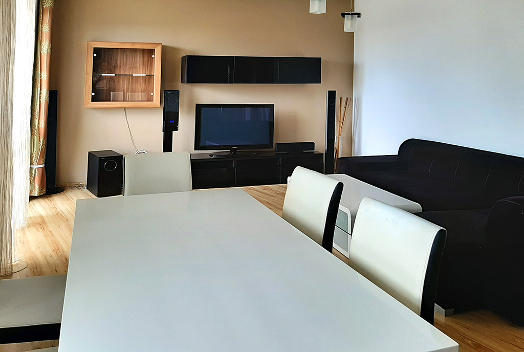 na pierwszym planie jadalnia, w oddali salon w ekskluzywnym apartamencie do wynajmu Piotrków Trybunalski