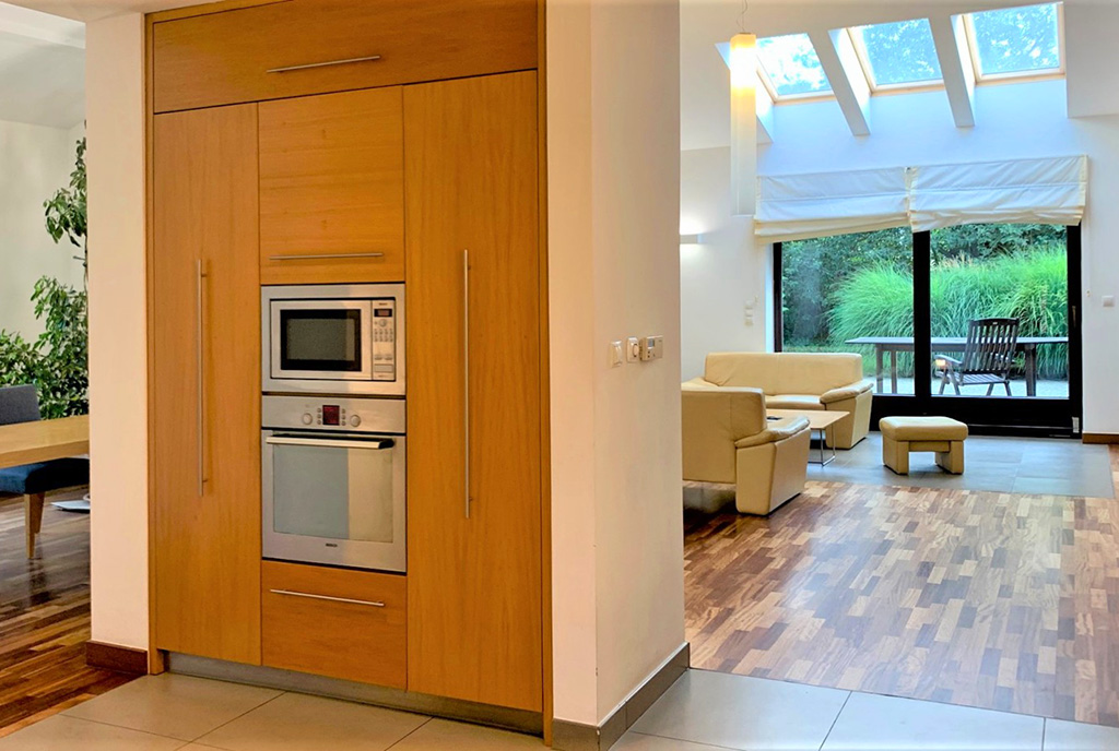 na pierwszym planie kuchnia, w oddali salon w luksusowej willi na sprzedaż Wrocław (okolice)