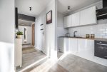 widok na kuchnię oraz przedpokój w ekskluzywnym apartamencie do sprzedaży Kalisz (okolice)