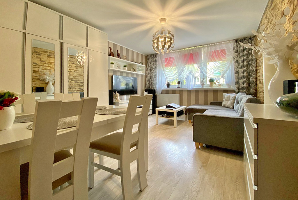 na pierwszym planie jadalnia, w oddali salon w ekskluzywnym apartamencie na sprzedaż Inowrocław