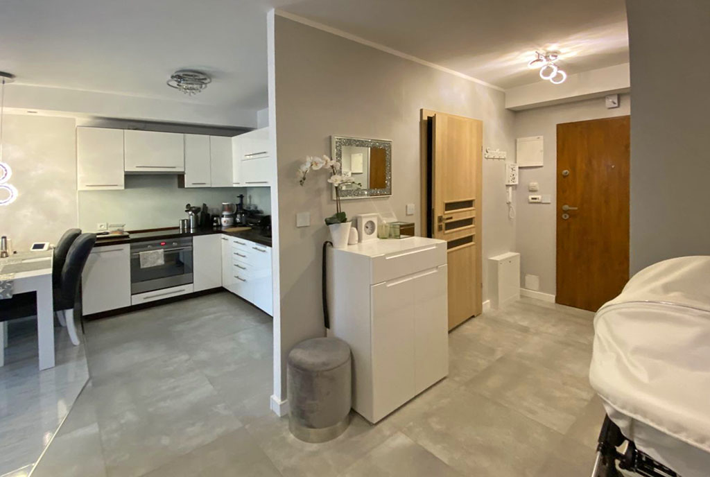 na zdjęciu salon, kuchnia oraz hol w ekskluzywnym apartamencie na sprzedaż Szczecin