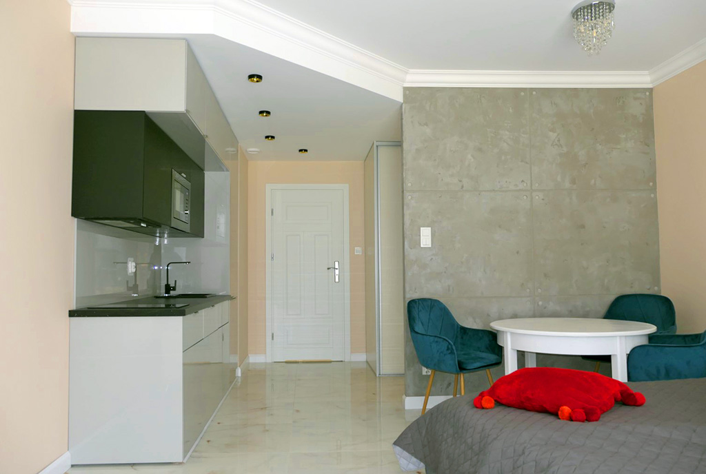 po prawej pokój dzienny, po lewej aneks kuchenny w ekskluzywnym apartamencie na wynajem Gdańsk