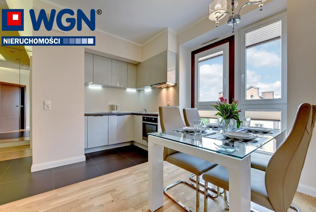 na pierwszym planie jadalnia, w oddali kuchnia w luksusowym apartamencie od wynajmu Gdańsk
