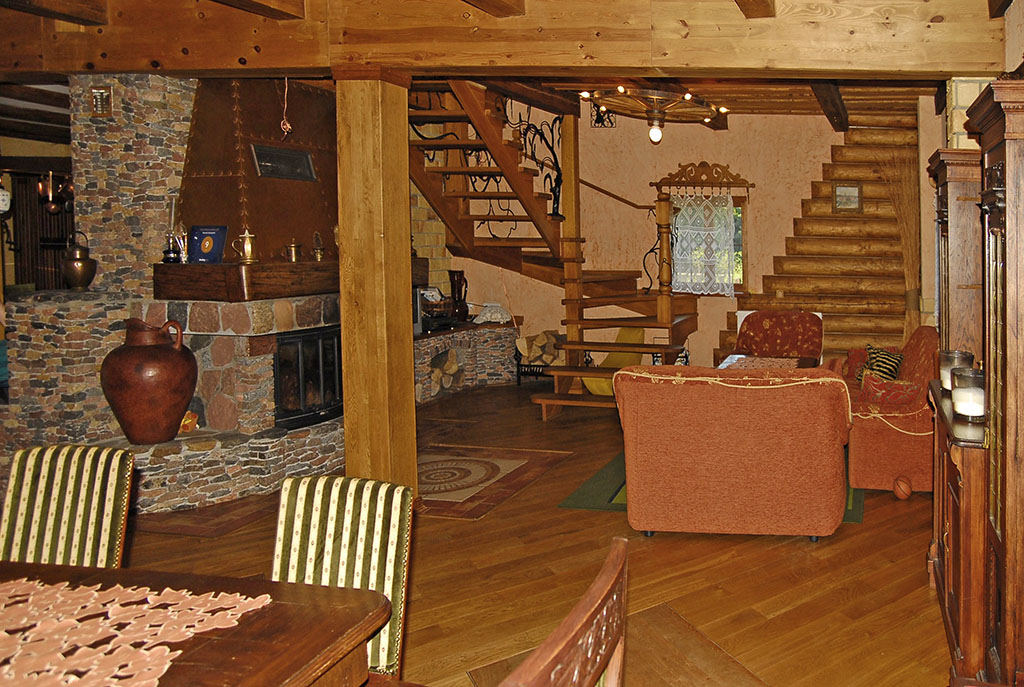na zdjęciu elitarny salon z kominkiem w ekskluzywnej willi do sprzedaży Mazury