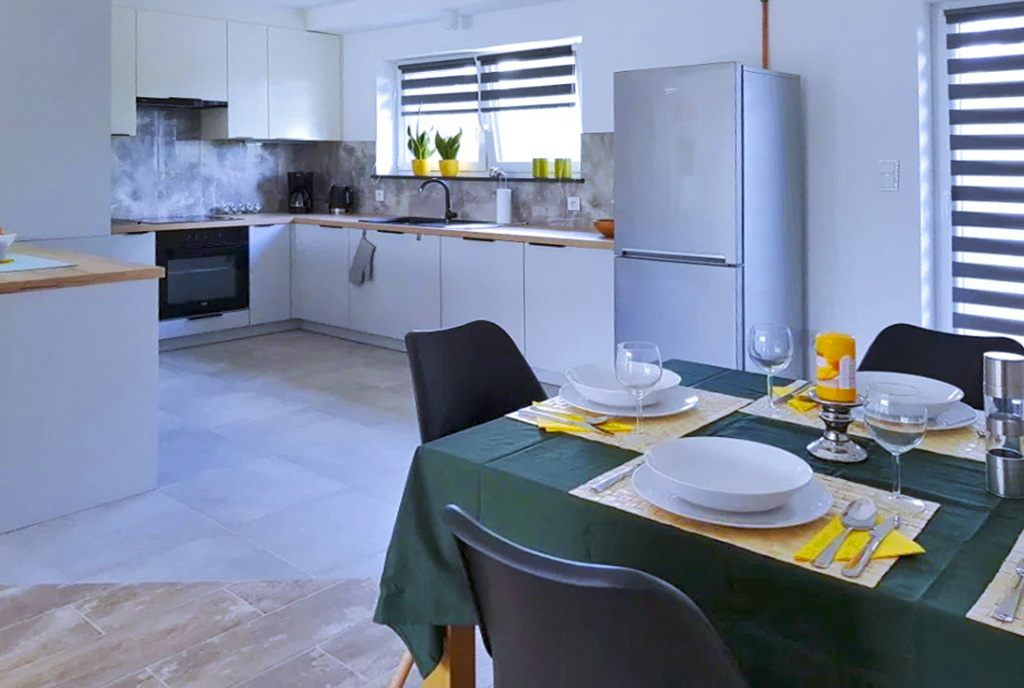 zbliżenie na jadalnię, w oddali kuchnia w luksusowym apartamencie do wynajęcia Szczecin
