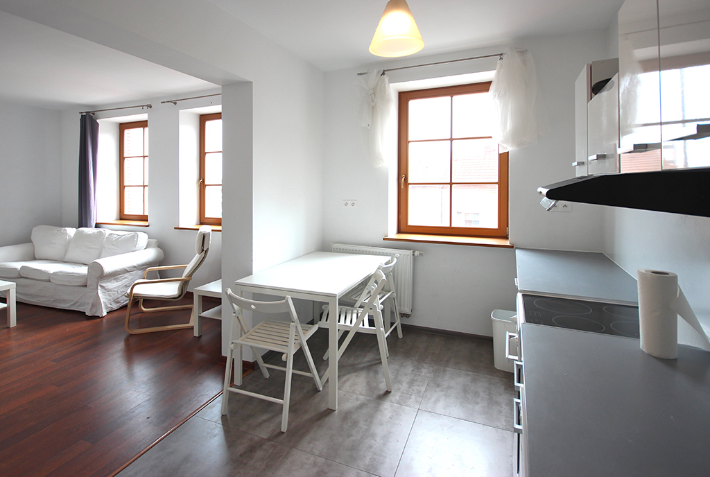 na pierwszym planie jadalnia i pokój dzienny w luksusowym apartamencie do wynajmu Szczecin