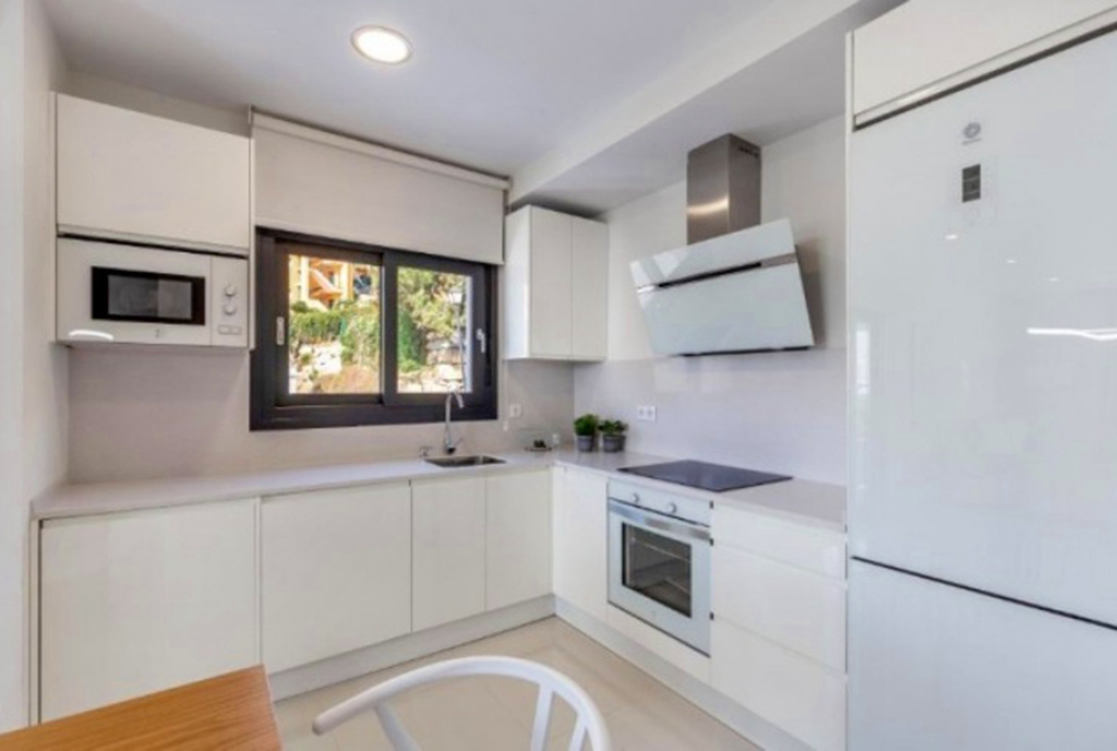 na pierwszym planie zabudowana kuchnia w luksusowym apartamencie na sprzedaż Hiszpania (Costa del Sol, Kadyks)