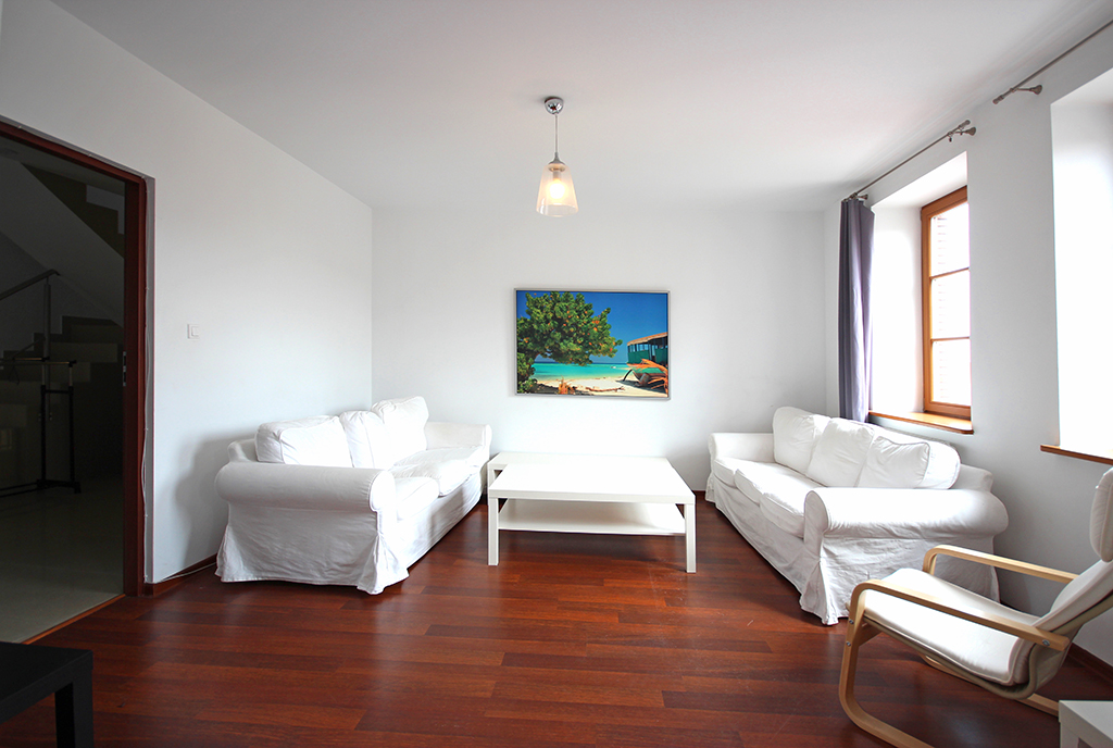 utrzymany w tonacji bieli salon ekskluzywnego apartamentu na wynajem Szczecin