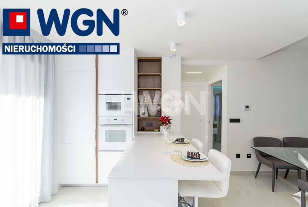na pierwszym planie jadalnia i kuchnia w ekskluzywnym apartamencie do sprzedaży Hiszpania (Torrevieja, Alicante)