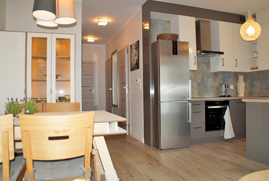 po lewej jadalnia, po prawej kuchnia w luksusowym apartamencie na wynajem Słupsk