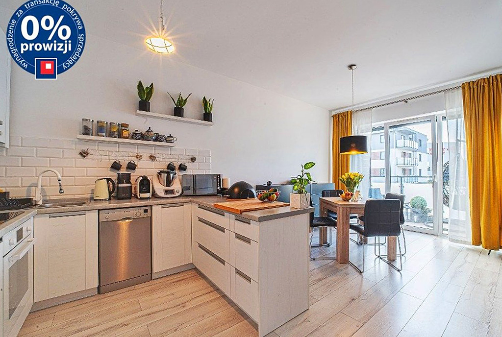 na pierwszym planie aneks kuchenny, a w oddali salon w luksusowym apartamencie na sprzedaż Bolesławiec