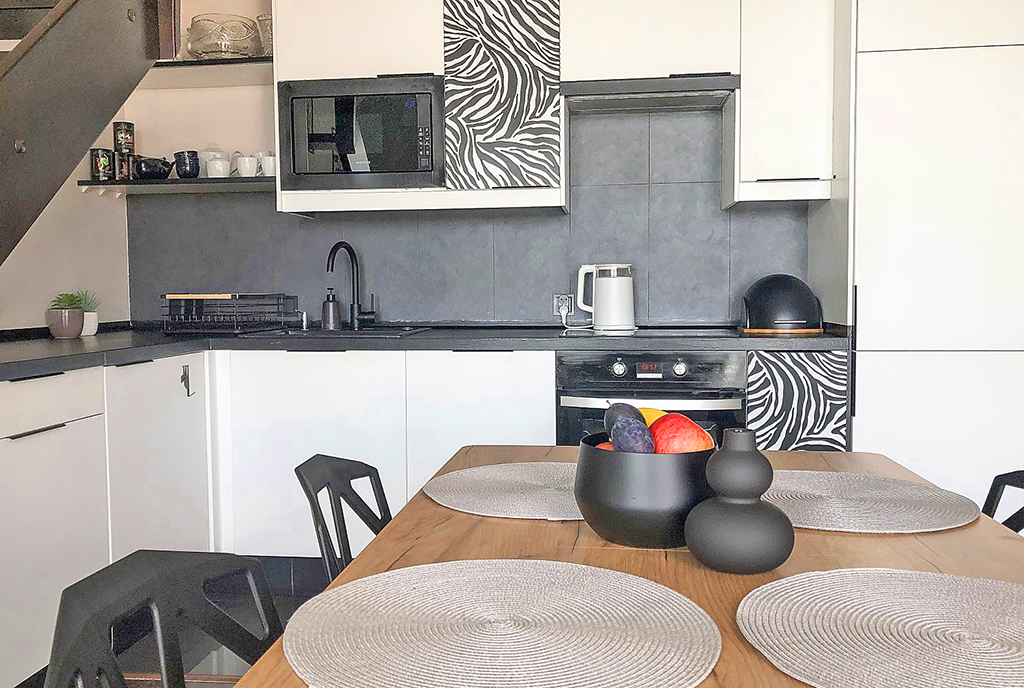 na pierwszym planie jadalnia i kuchnia w ekskluzywnym apartamencie do sprzedaży Gdańsk