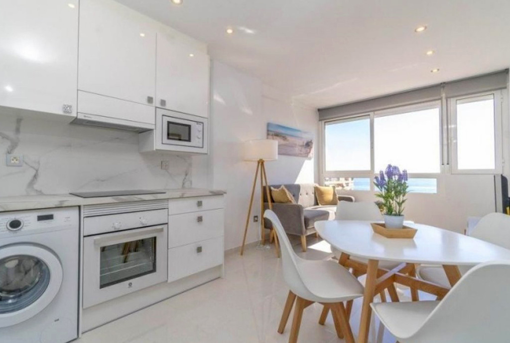 na pierwszym planie jadalnia, w oddali kuchnia w luksusowym apartamencie na sprzedaż Hiszpania (Costa Blanca, La Mata)
