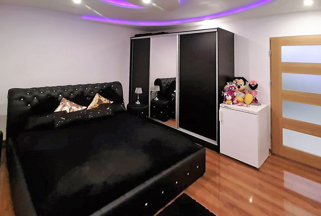 elegancka sypialnia z gustownym oświetleniem w ekskluzywnym apartamencie na sprzedaż