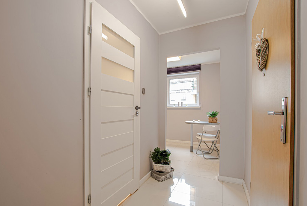 utrzymany w jasnych kolorach przedpokój w luksusowym apartamencie na wynajem Poznań